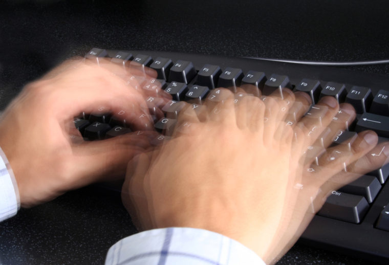person typing incredibly fast on a keyboard